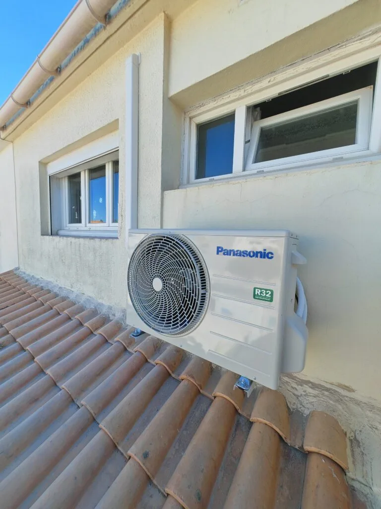 Unité extérieure Panasonic fixée sur un toit en tuiles, sous les fenêtres de l’étage
