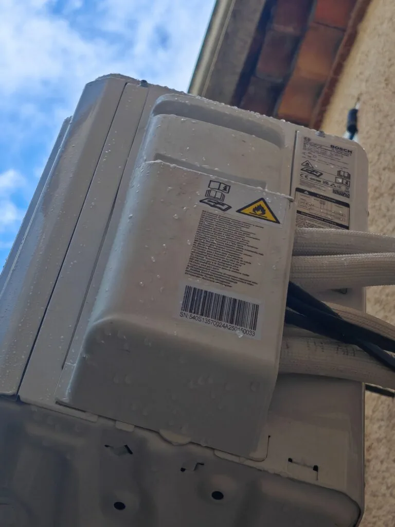 Gros plan sur une unité extérieure de climatisation et ses liaisons frigorifiques isolées