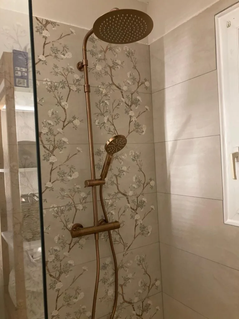 Colonne de douche thermostatique dorée, faïence florale